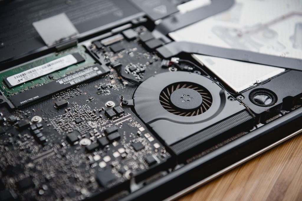 Detailed view of a laptops internal circuitry and cooling fan showcasing technology and engineering.